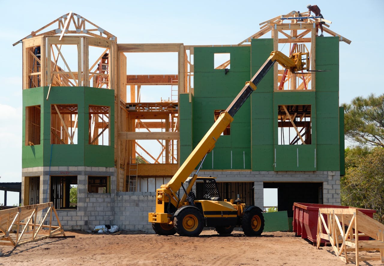 Mastering the First Impression: Your intriguing post title goes here A multi-story wooden house under construction using a crane on a sunny day.